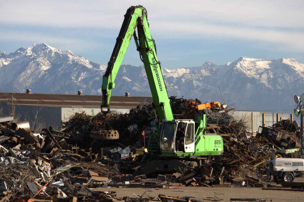 Green industrial equipment sorting metal scraps.