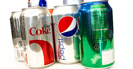 A collection of soda cans arranged on a plain white background.