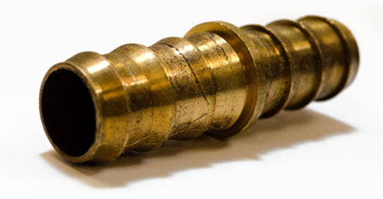 A brass pipe fitting on a white surface, suitable for plumbing projects.