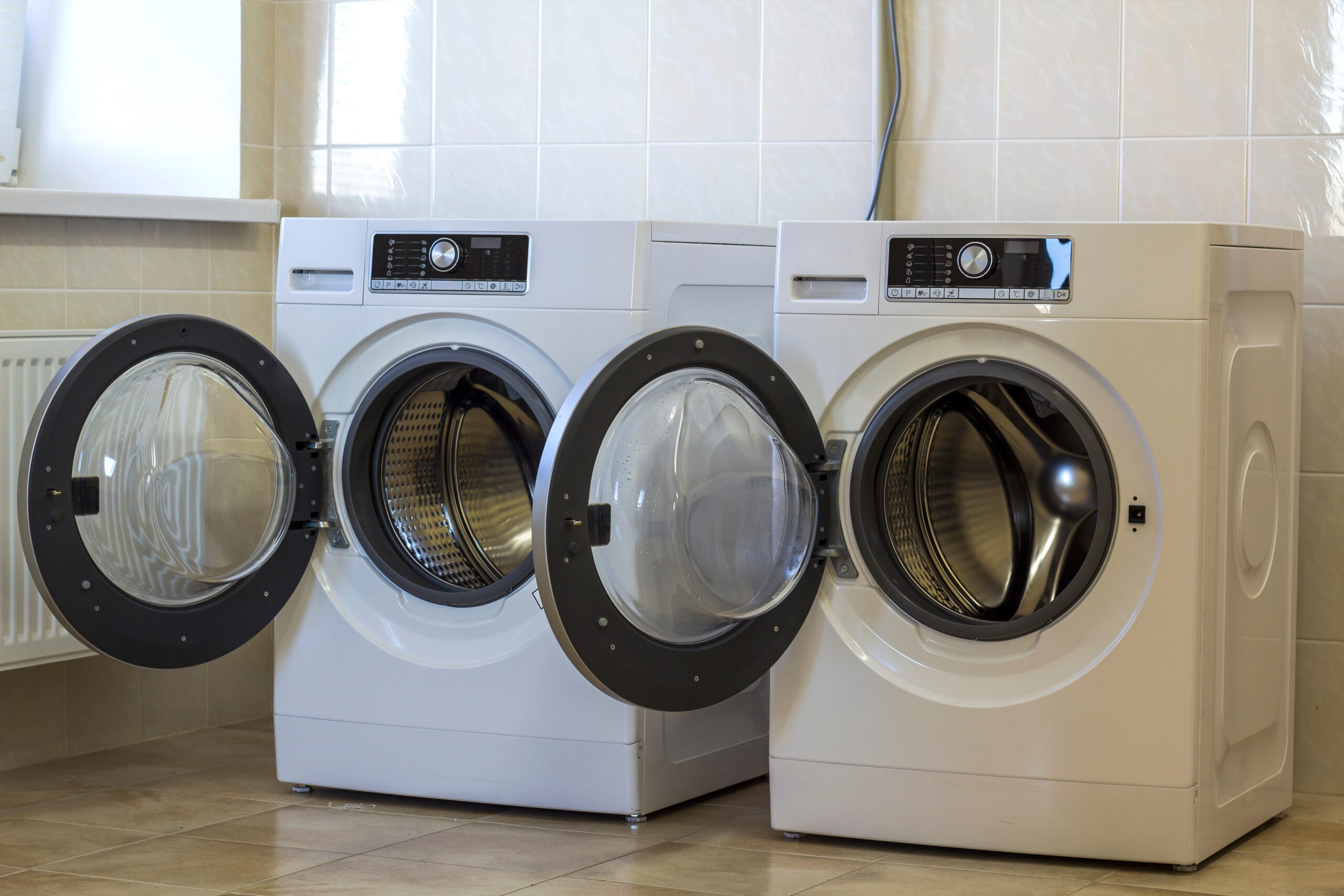 Two open washing machines in bathroom - Metro Group